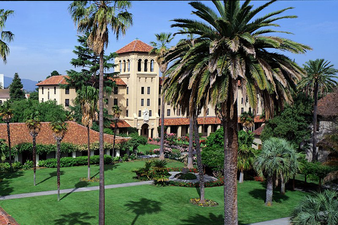 Mission-style campus buildings framed by palm trees