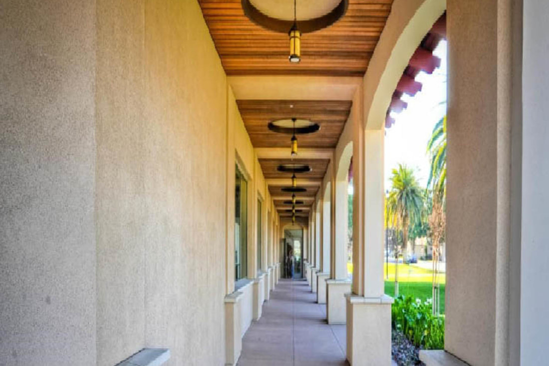 Covered mission-style walkway with arches and pendant lights
